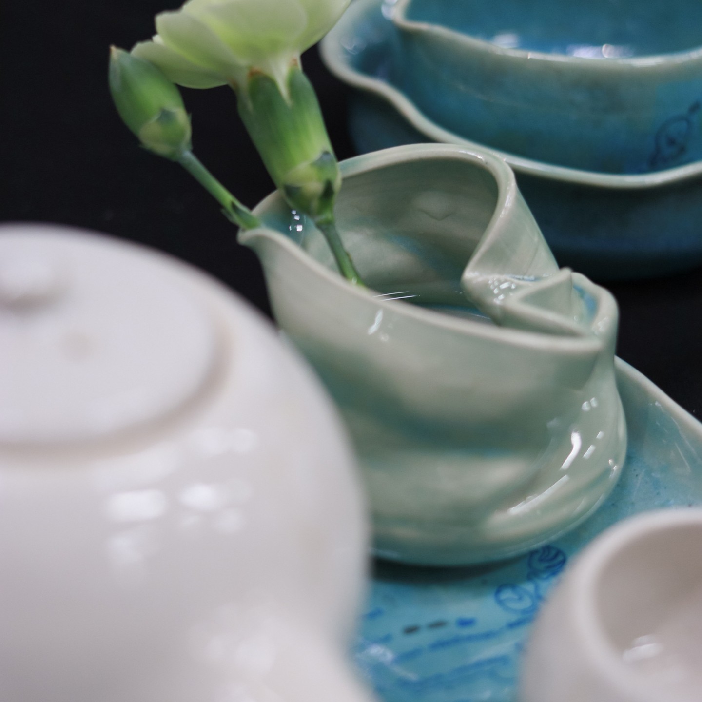 A small greenish-blue ceramic vase